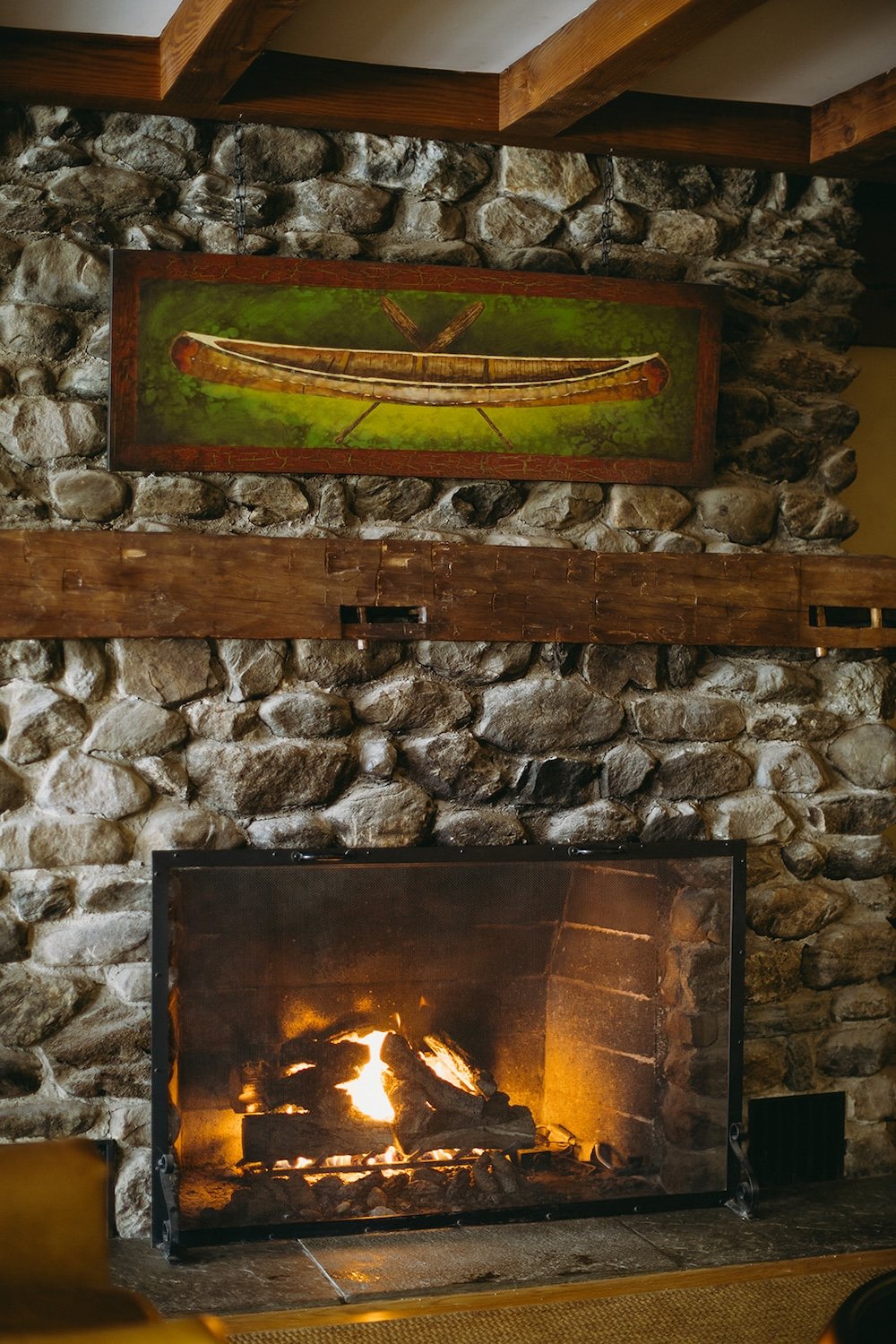 Stone fire place decorated with a painted kayak portrait.