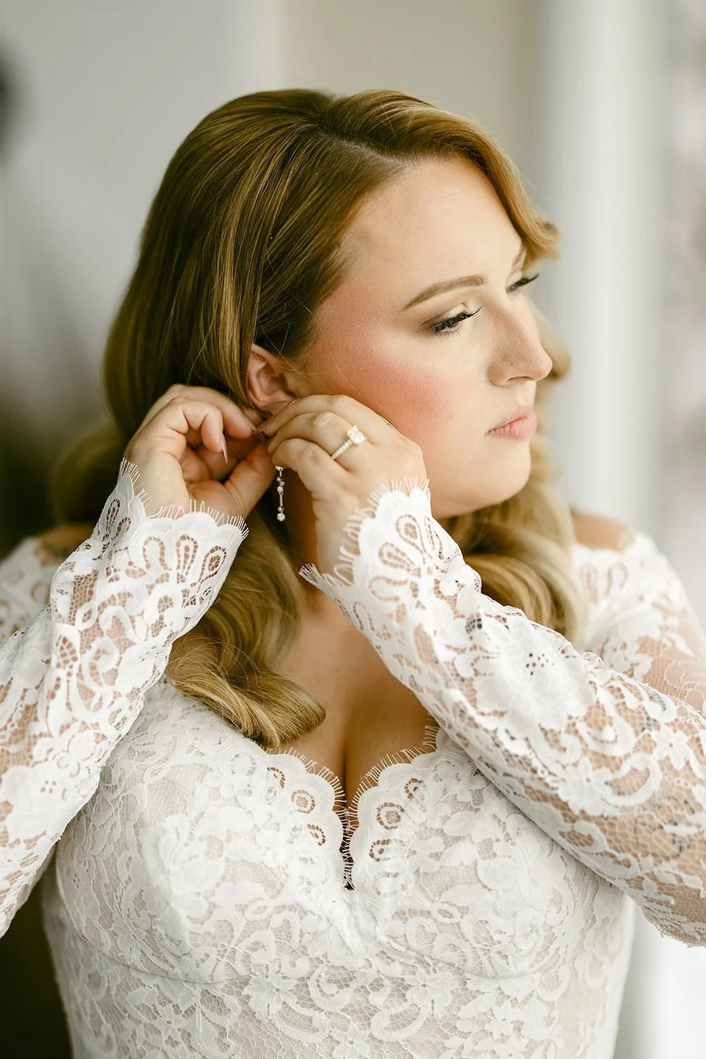 The bride puts her wedding jewelry on.