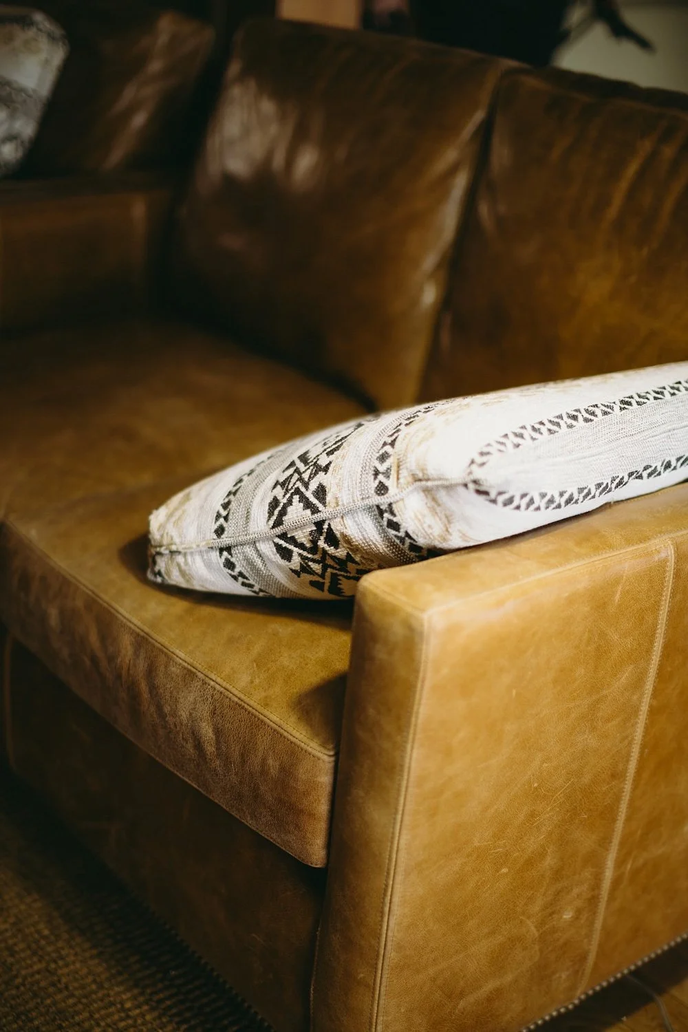 Tan leather couch rests in the wedding venue. 
