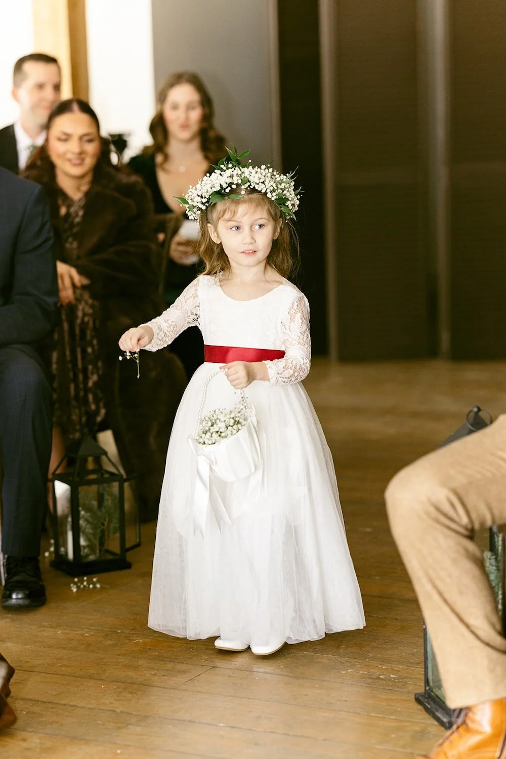 The young flower girl walks down the aisle.