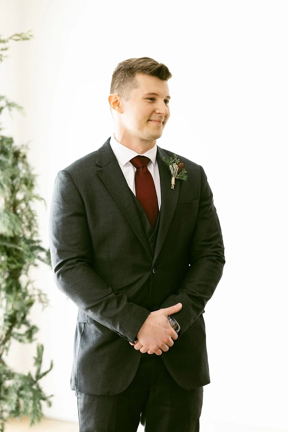 The groom stands at the arbor awaiting his bride to be. 