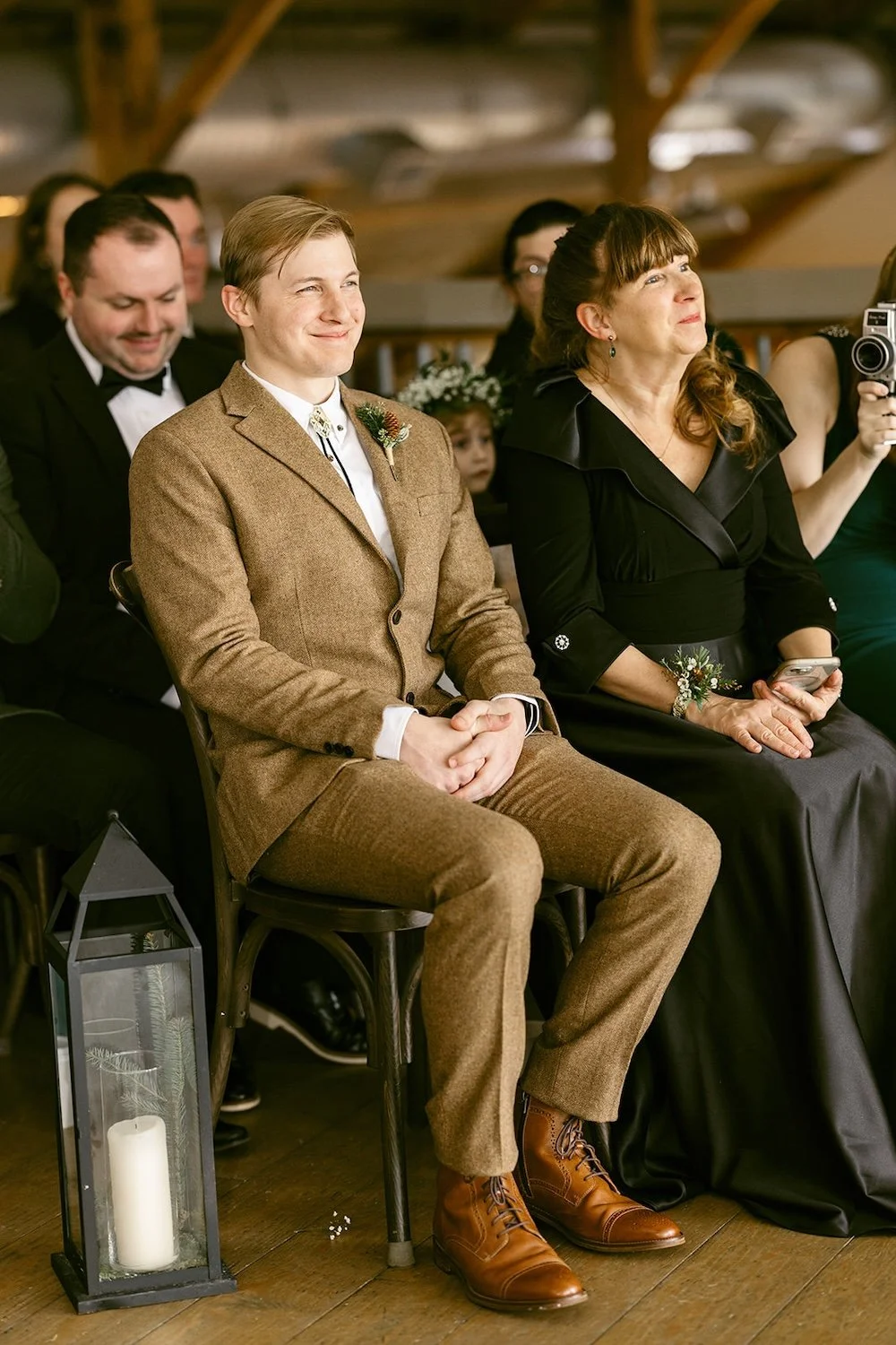 Guests of the wedding sit with smiles of job for the couple. 