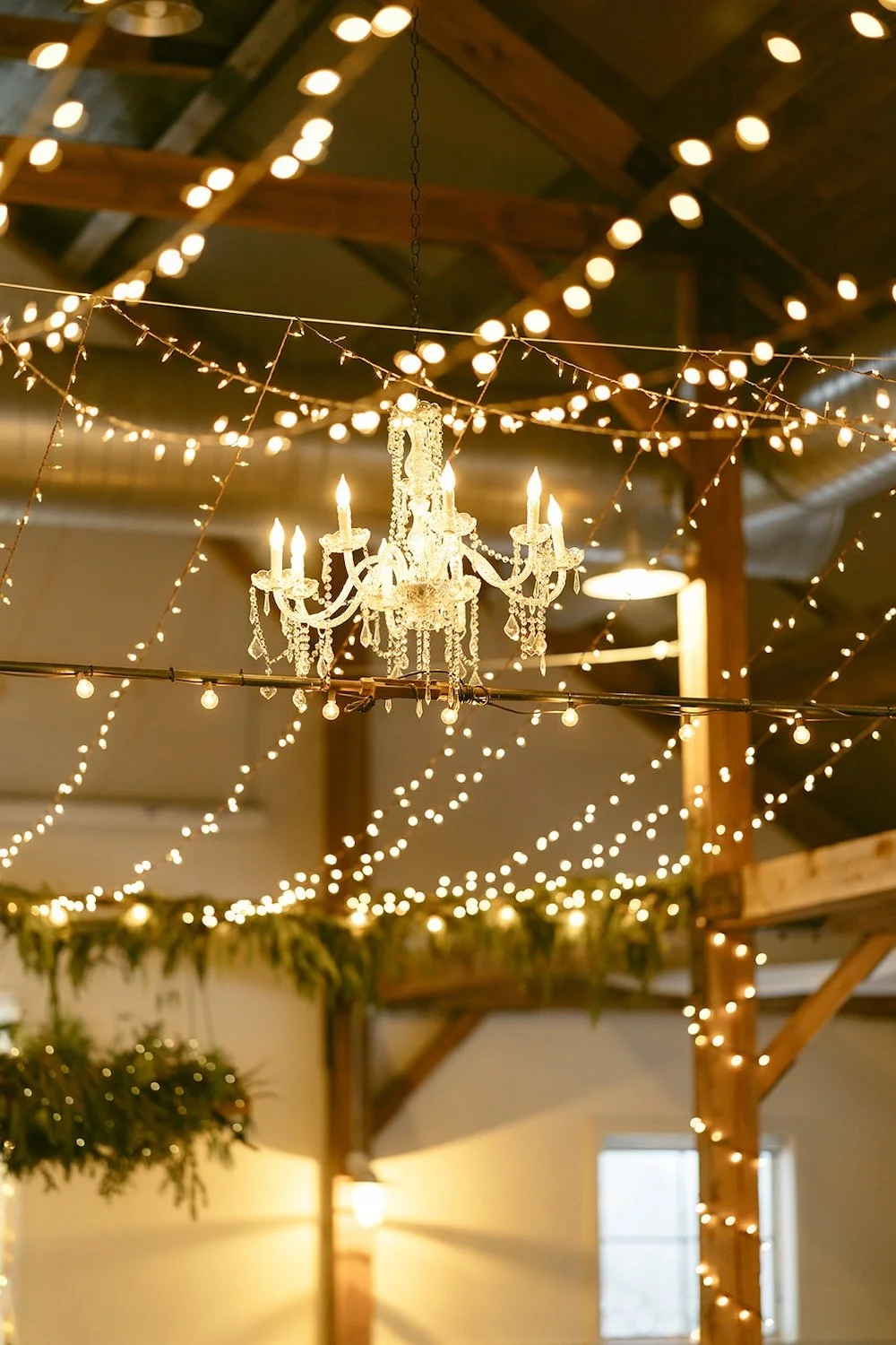 Hanging lights and chandeliers hang from the rafters of the venue. 