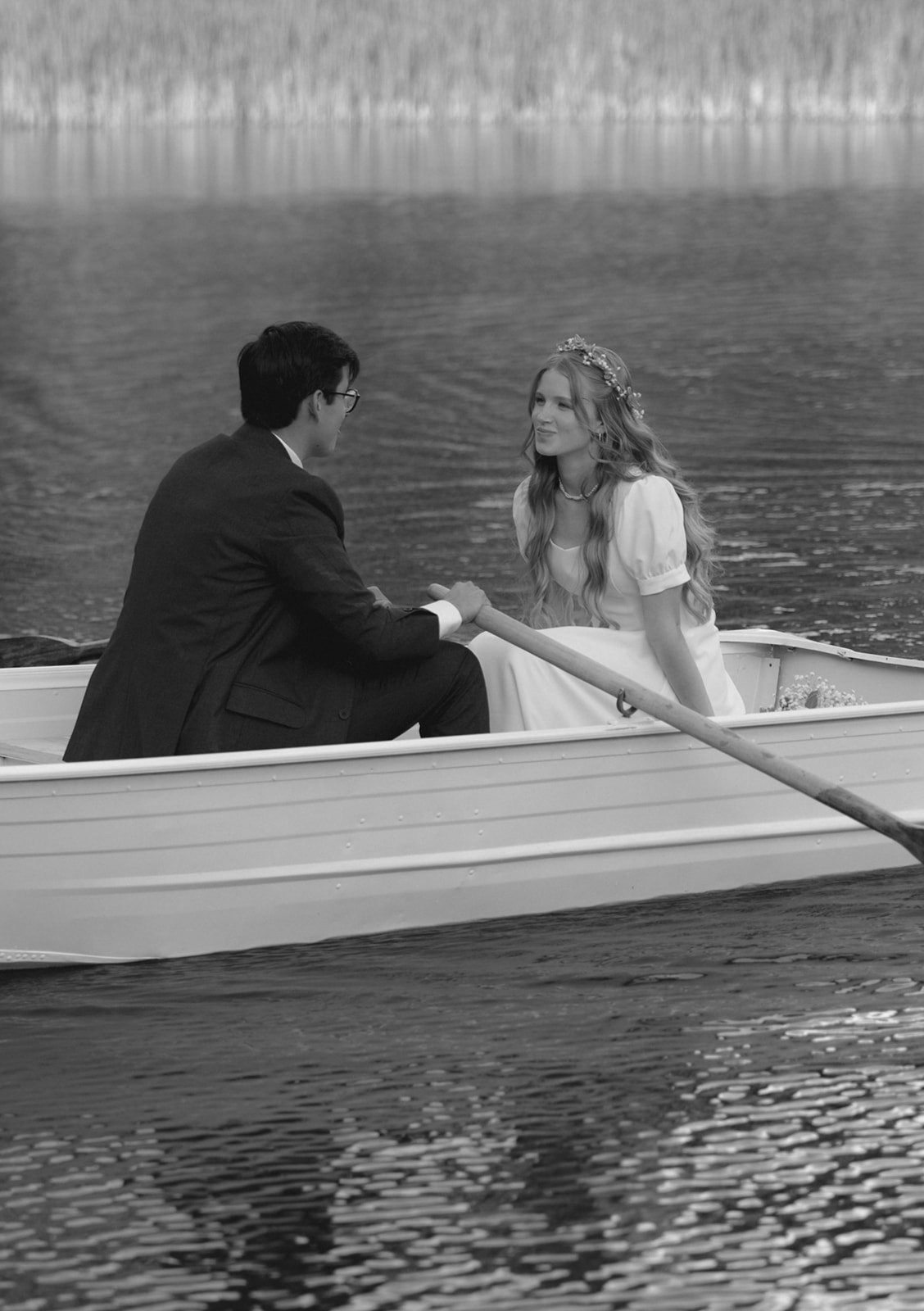 A couple stands on a wooden dock above a pond, their lower bodies and clear reflection visible in the water below for a christ-centered marriage