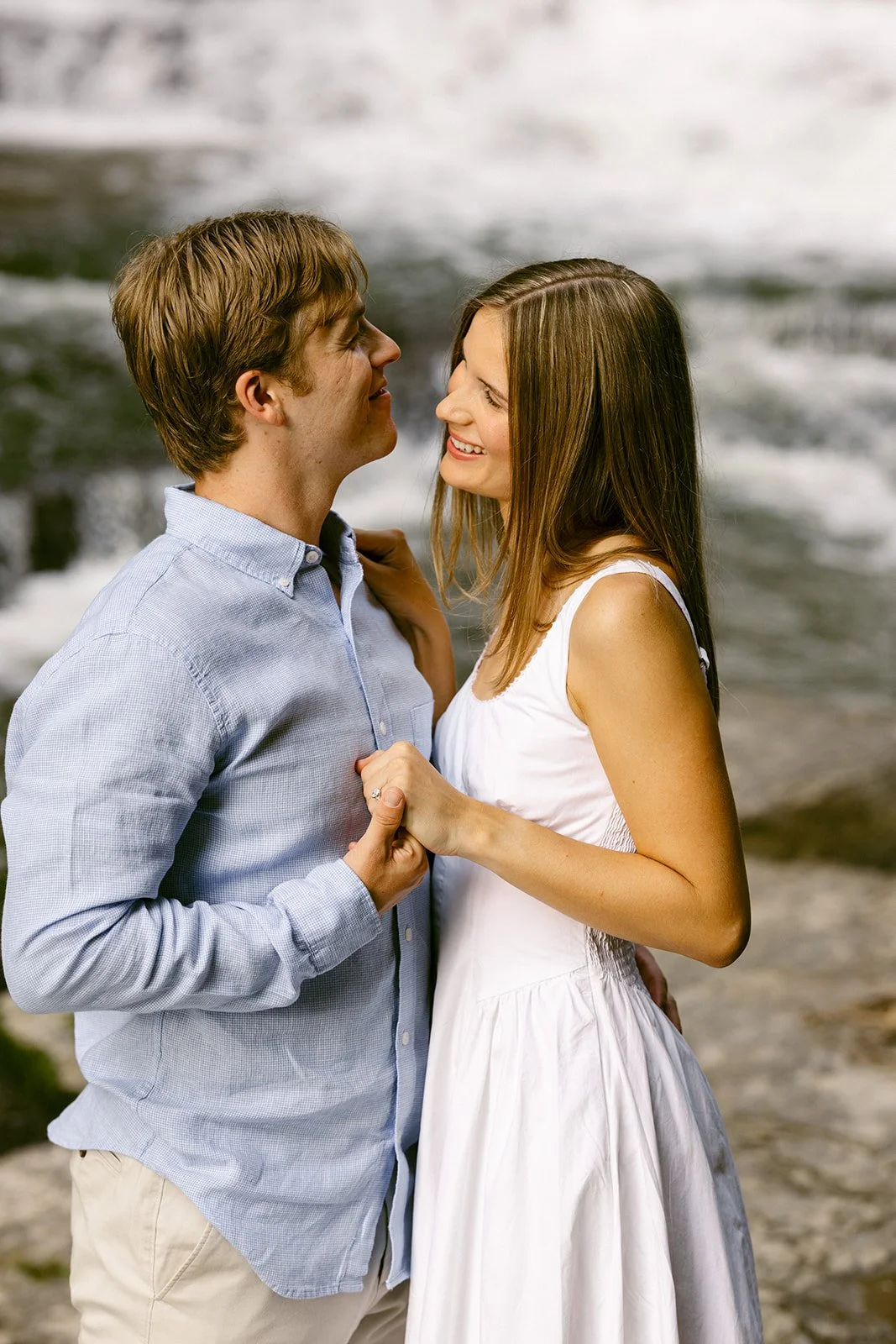 Couple taking engagement photos by waterfalls in Upstate NY at Cascadilla Gorge in Ithaca, New York