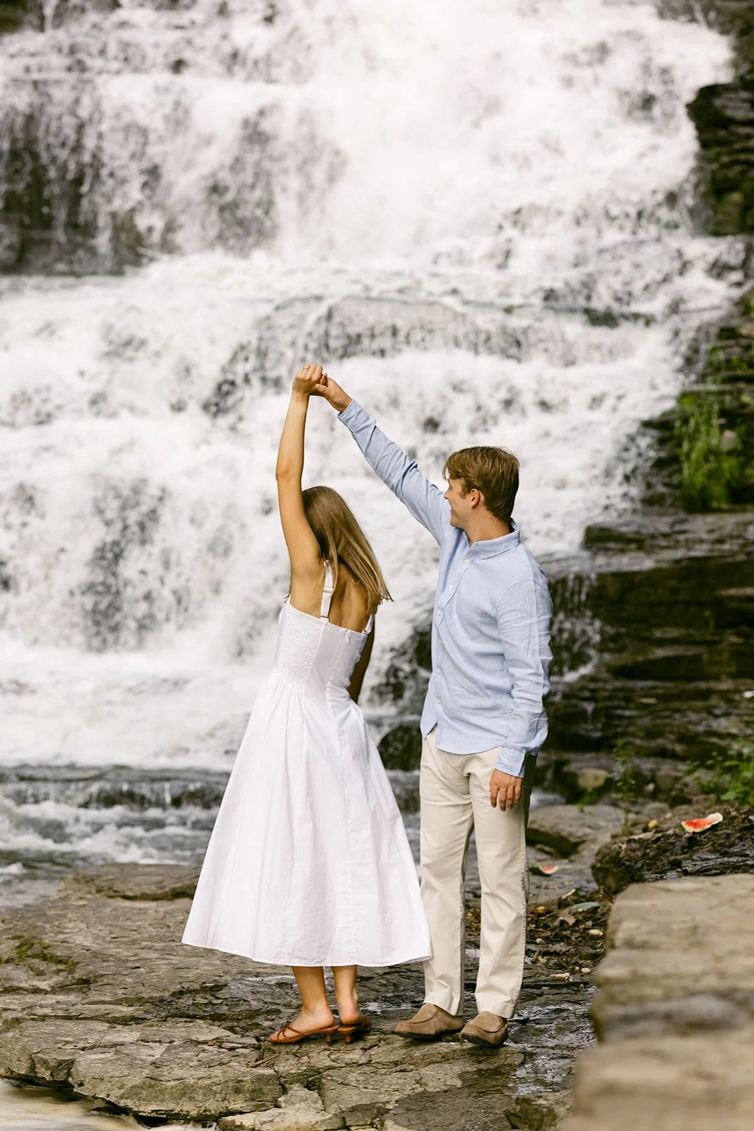 Couple taking engagement photos by waterfalls in Upstate NY at Cascadilla Gorge in Ithaca, New York