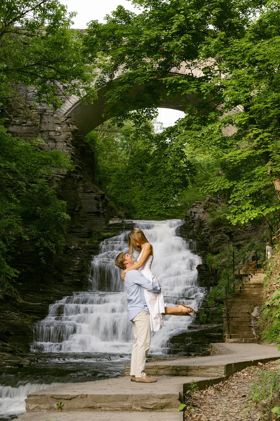 Couple taking engagement photos by waterfalls in Upstate NY at Cascadilla Gorge in Ithaca, New York