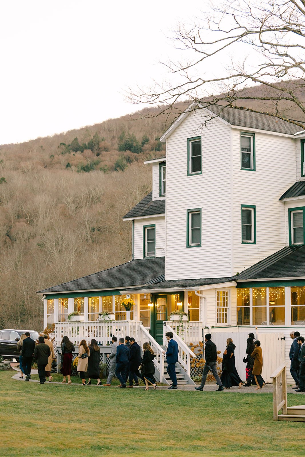 The wedding guests walk toward the venue to enter for the reception.