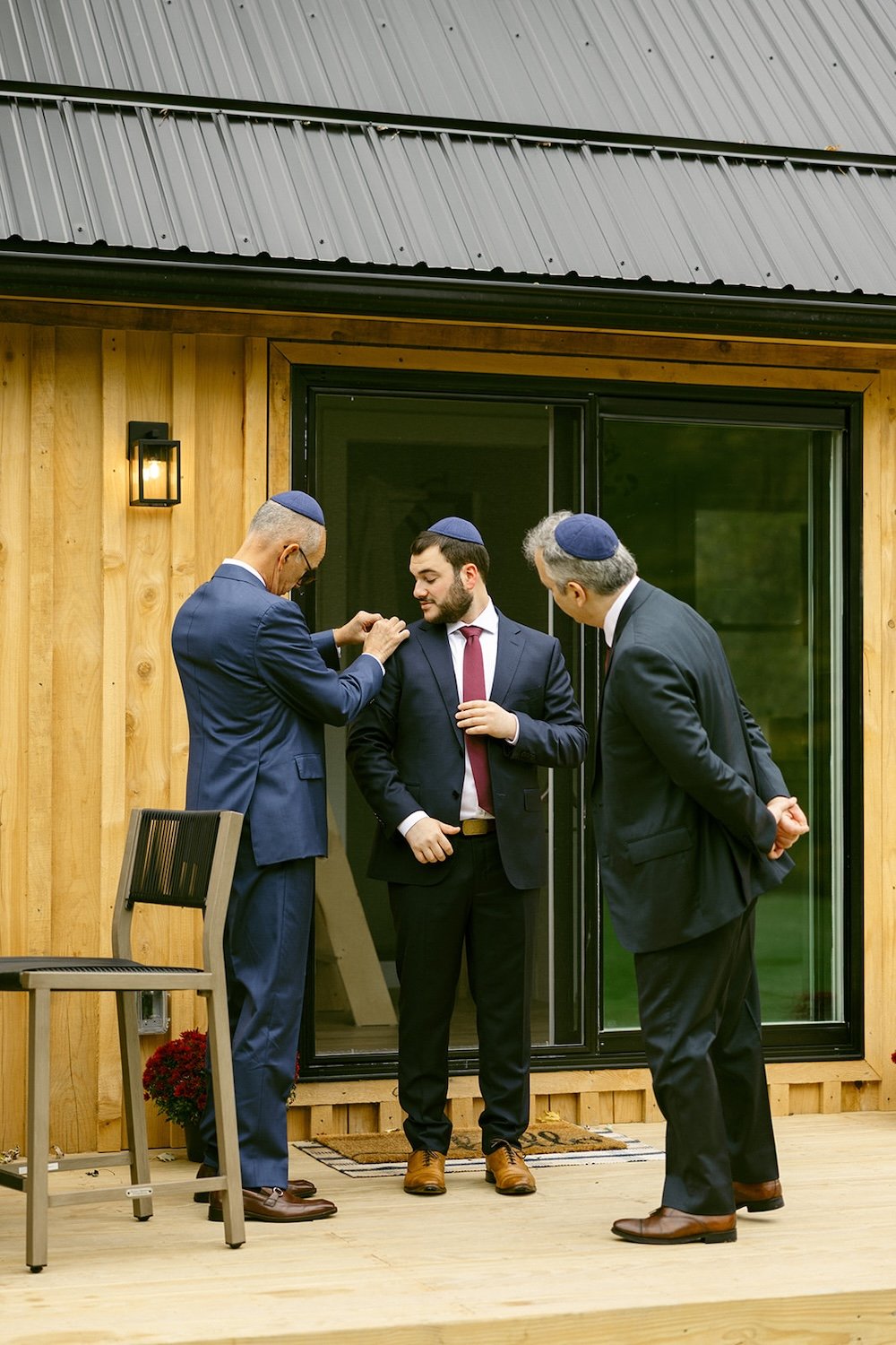 The groom and his family getting ready for the wedding festivities outside of the cottage.