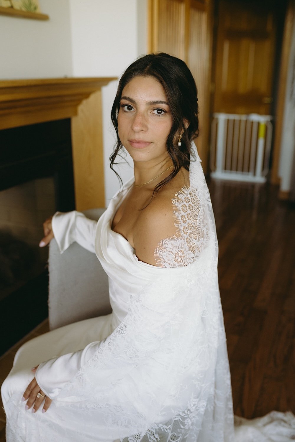 The bride sits in her wedding attire posing with elegance.