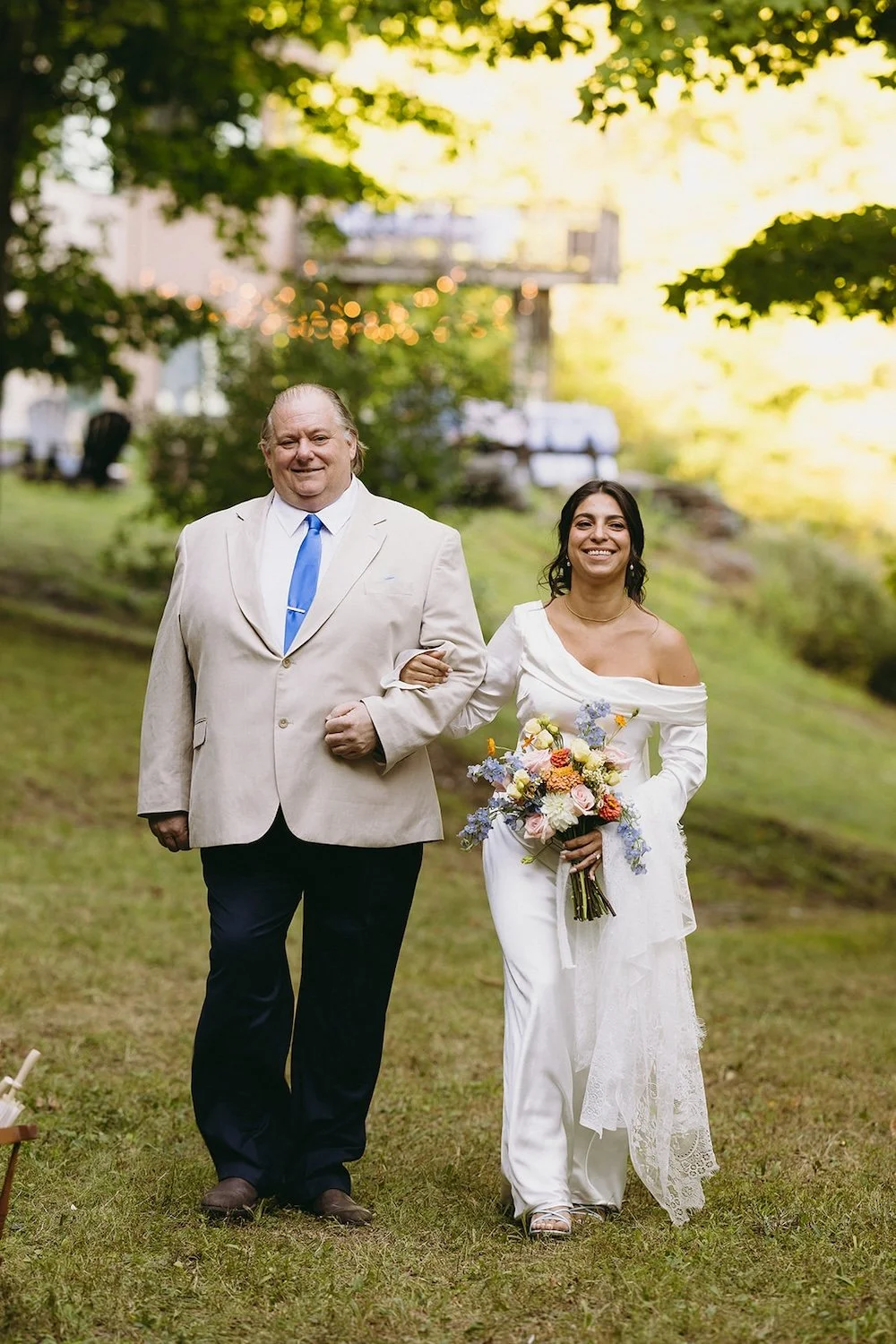 The bride walking the aisle with her brother by her side.