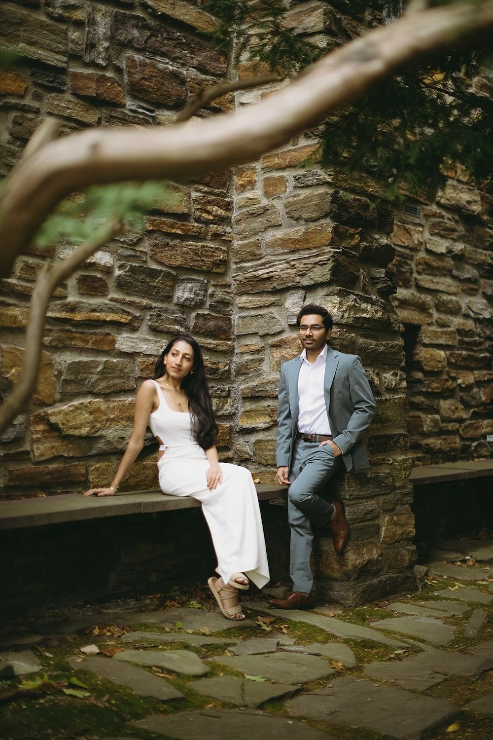 The couple rest on the bench and against the wall of the church admiring the building surrounding them.