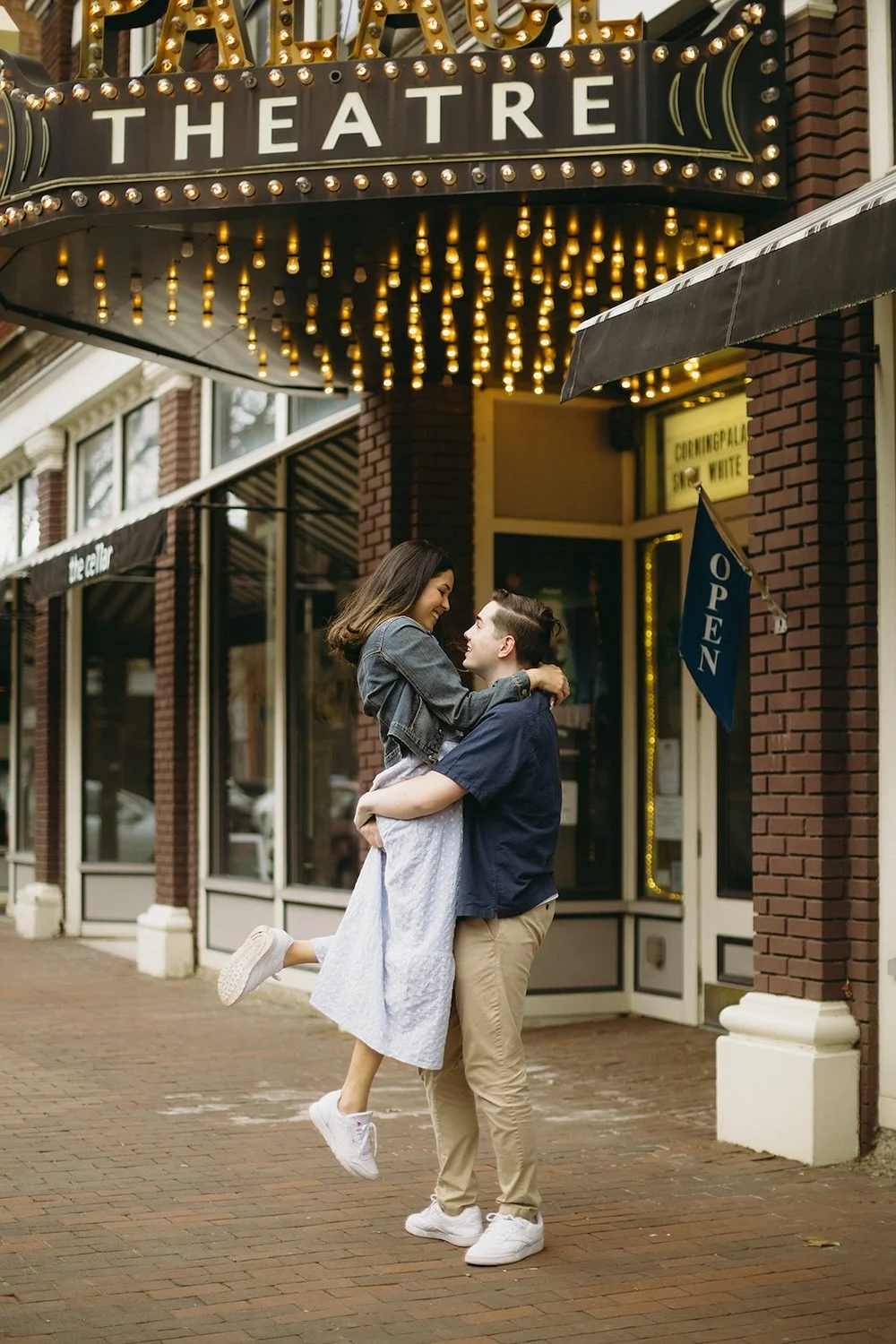 The future groom lifts his future bride in the air.