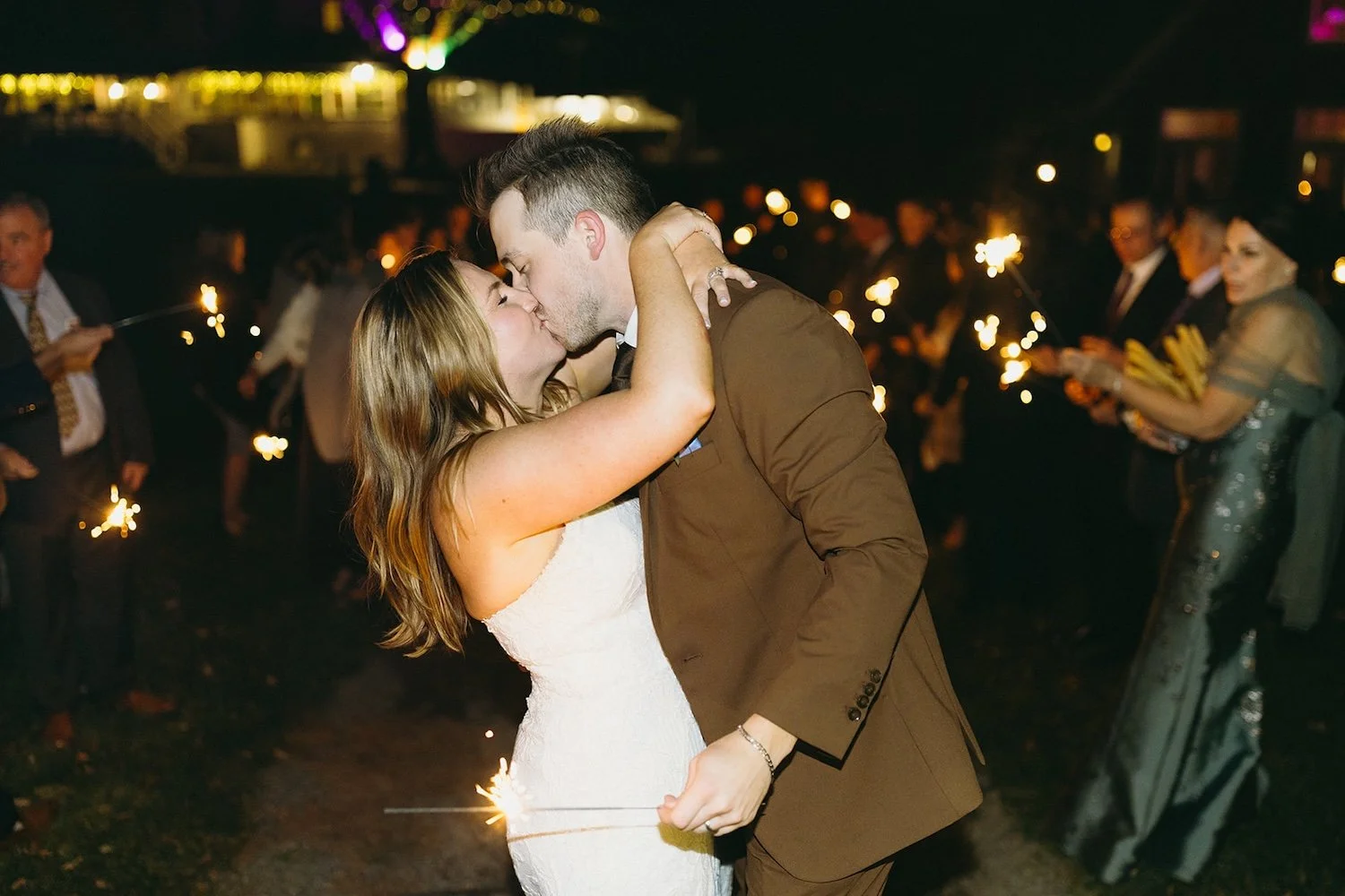 The bride and groom share a kiss during their sparkler exit.