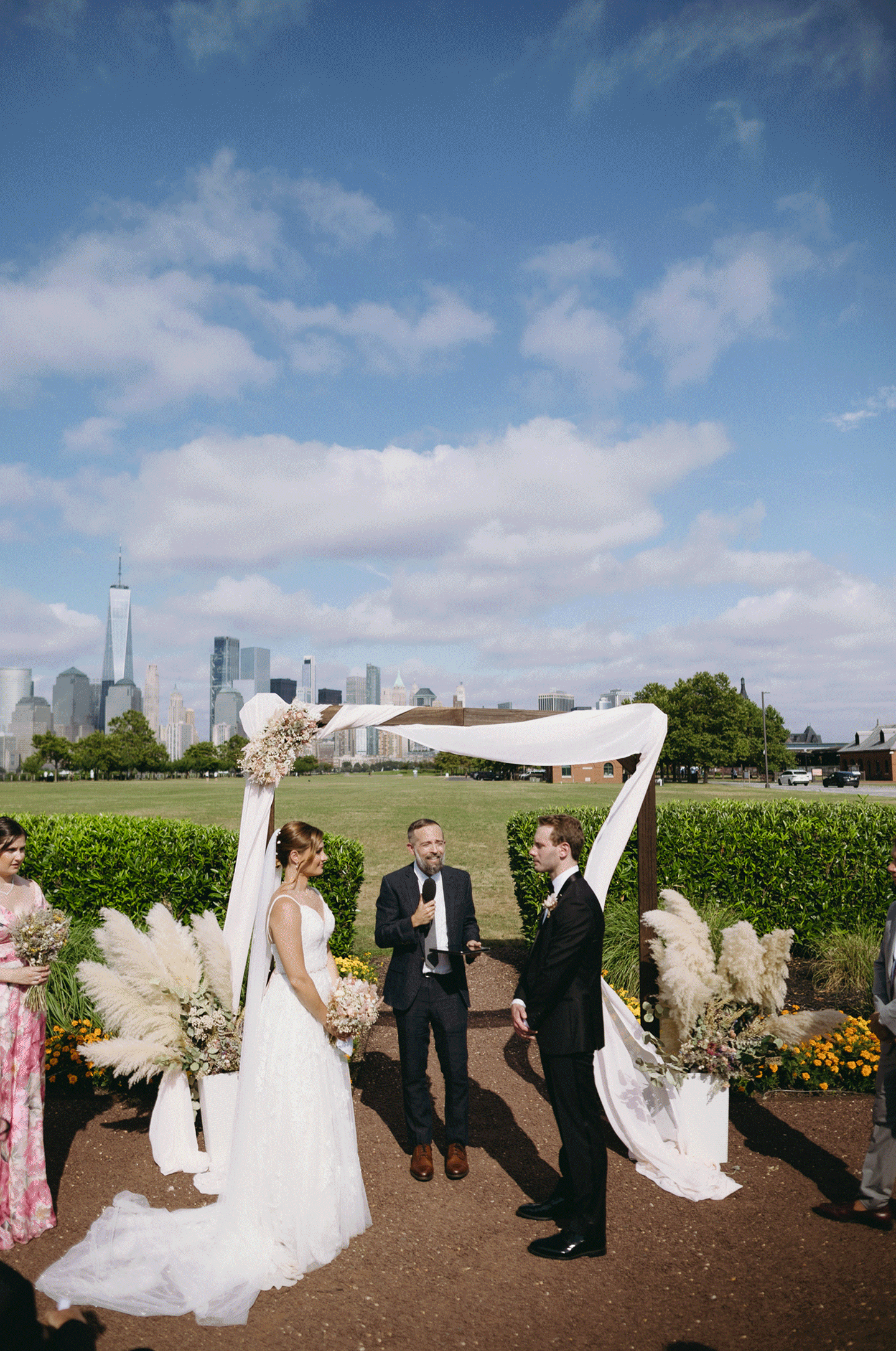 GIF photo of the bride and groom standing at the arch listening to their pastor.