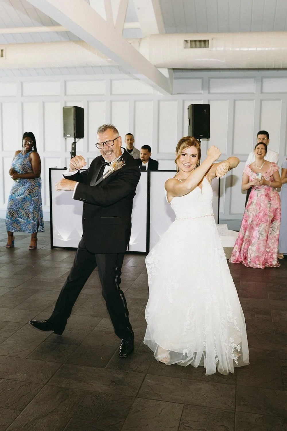 The dad and bride laugh while showing off their choreographed dance.