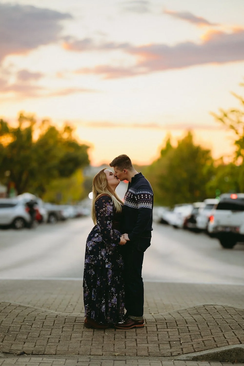 Blue hour photo of the couple kissing at the crosswalk.