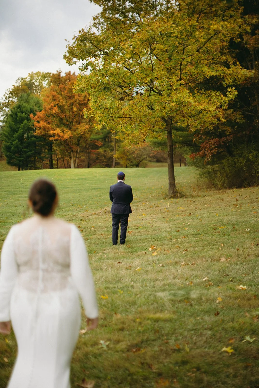 The bride walks toward her groom as they prepare for their first look.