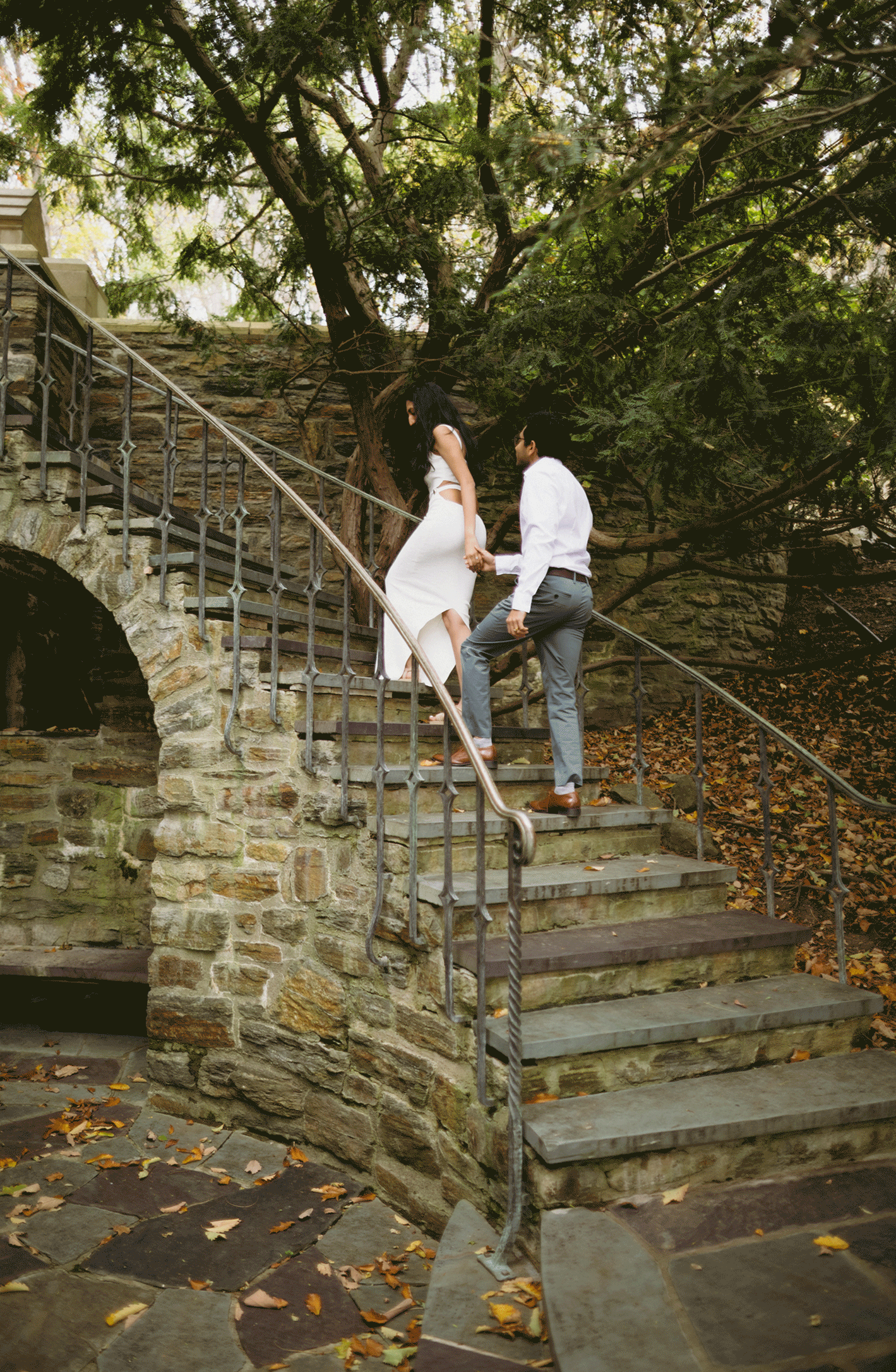 The couple walk up the steps together as they hold hands.