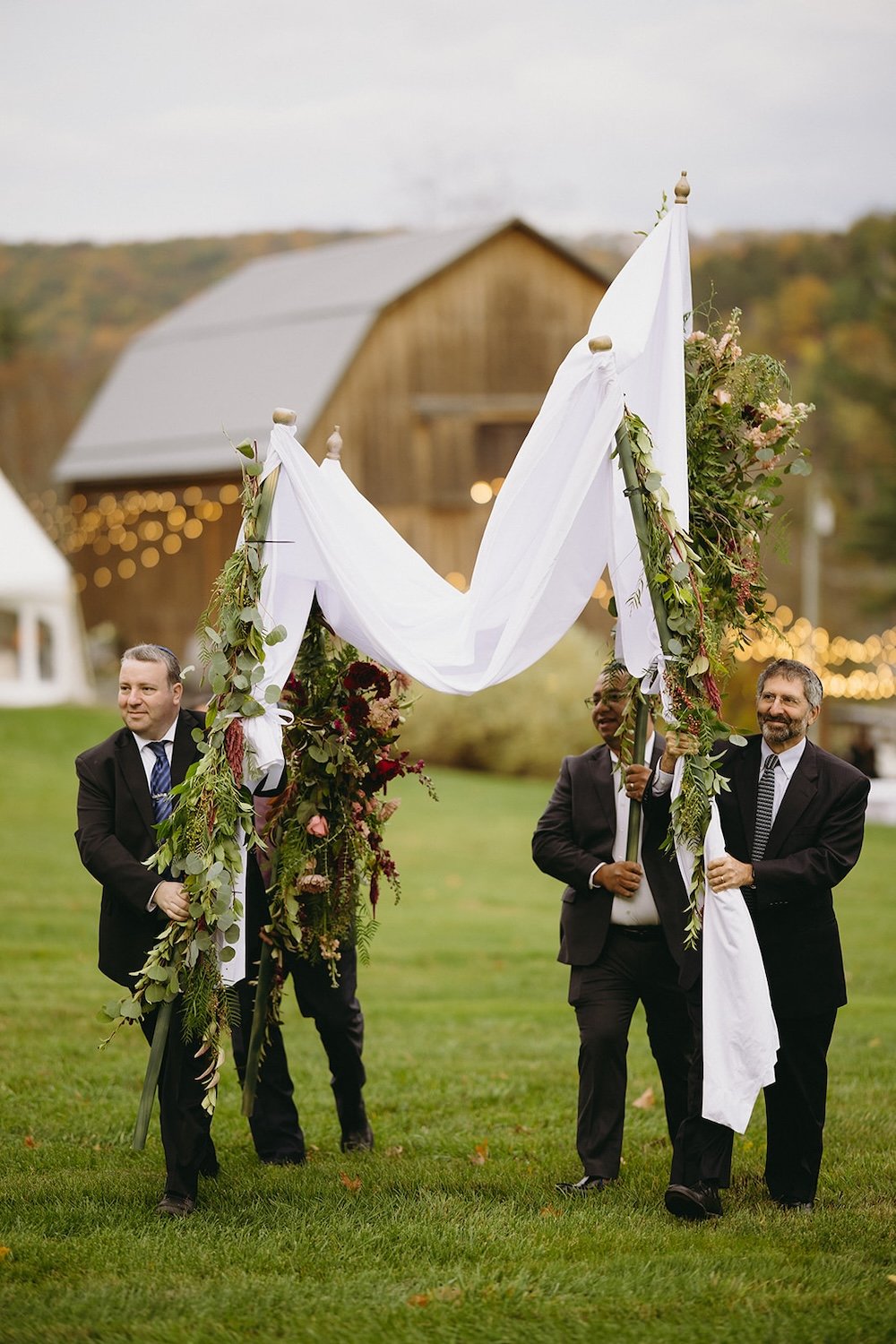 Family of the wedding carrying the chuppah to the wedding ceremony location.