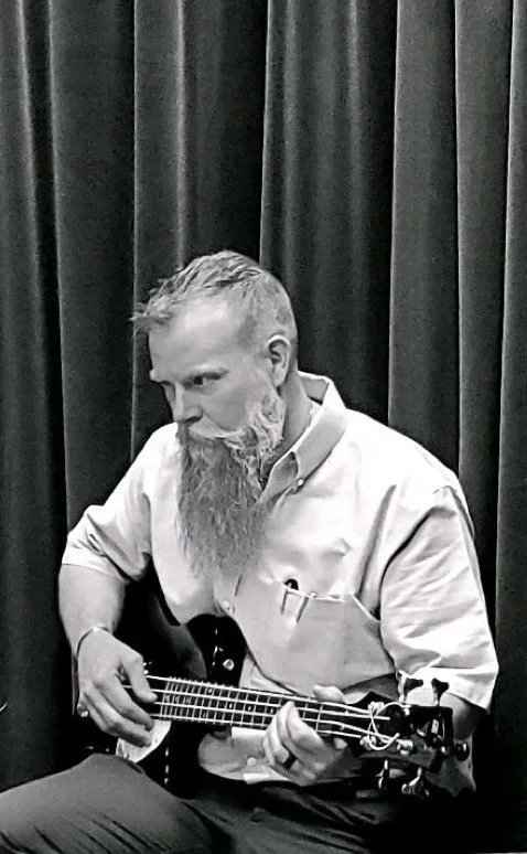 Dr. Adam Lynskey playing bass guitar