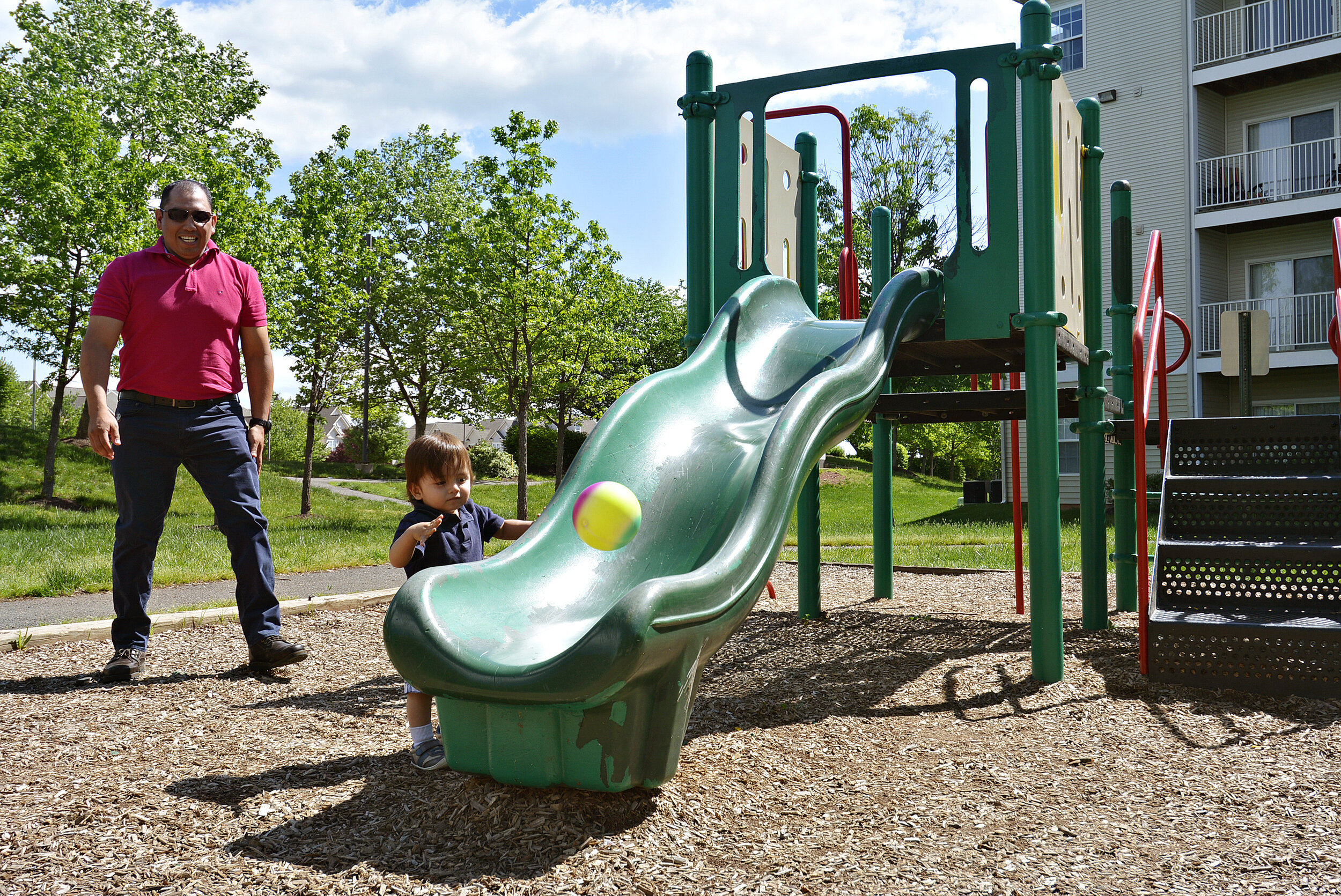  A father and daughter enjoying time at the park at Ashburn Meadows Apartments. 