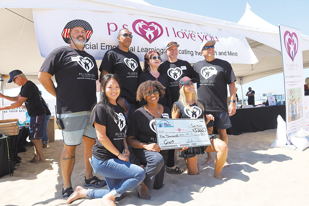  The PS I Love You Foundation Board accepts a $5,000 check from SheAngeles Holly Powell (standing, center). 