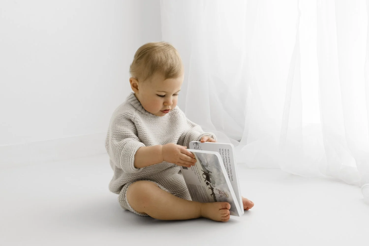 baby reading a board book at a calm first birthday photography session in Broughty Ferry