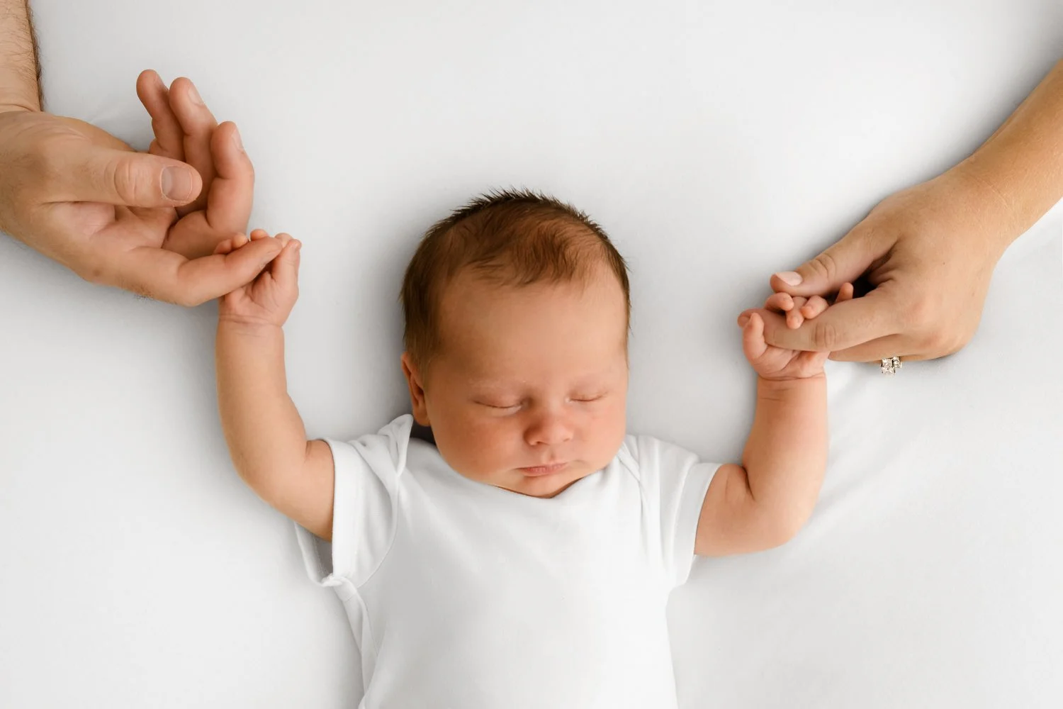 parents holding 14 day old newborn baby hands at Mabel and Moose studio Monifieth Dundee