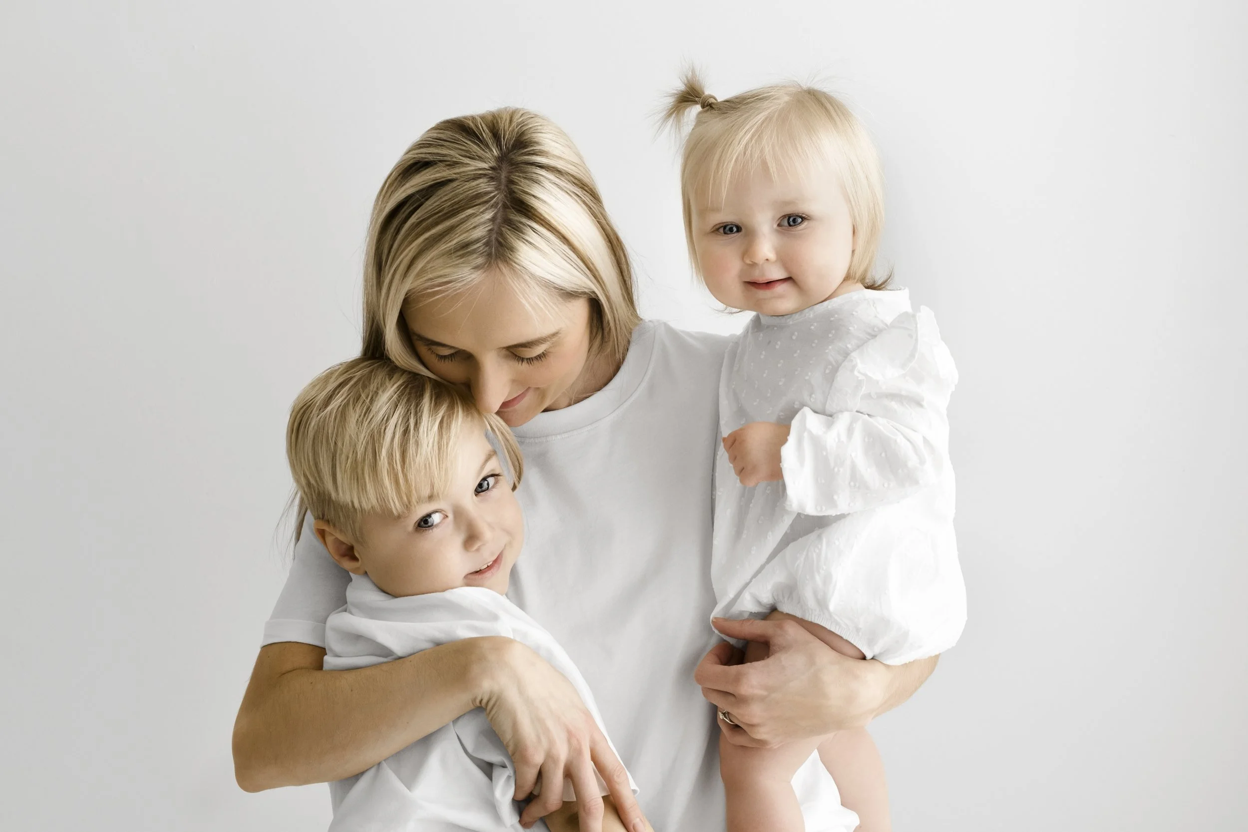 Mum hugging first birthday baby and sibling during Dundee studio photoshoot
