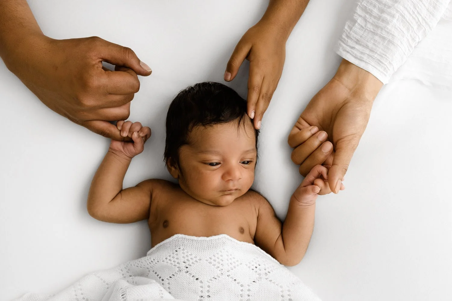 parents and siblings hands on baby at Natural prop free newborn baby photography at Mabel and Moose studio Monifieth Dundee