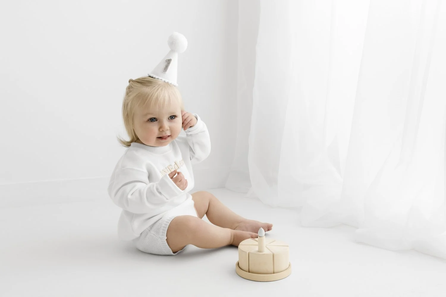 Baby playing with wooden birthday cake at first birthday photoshoot Mabel and Moose Dundee