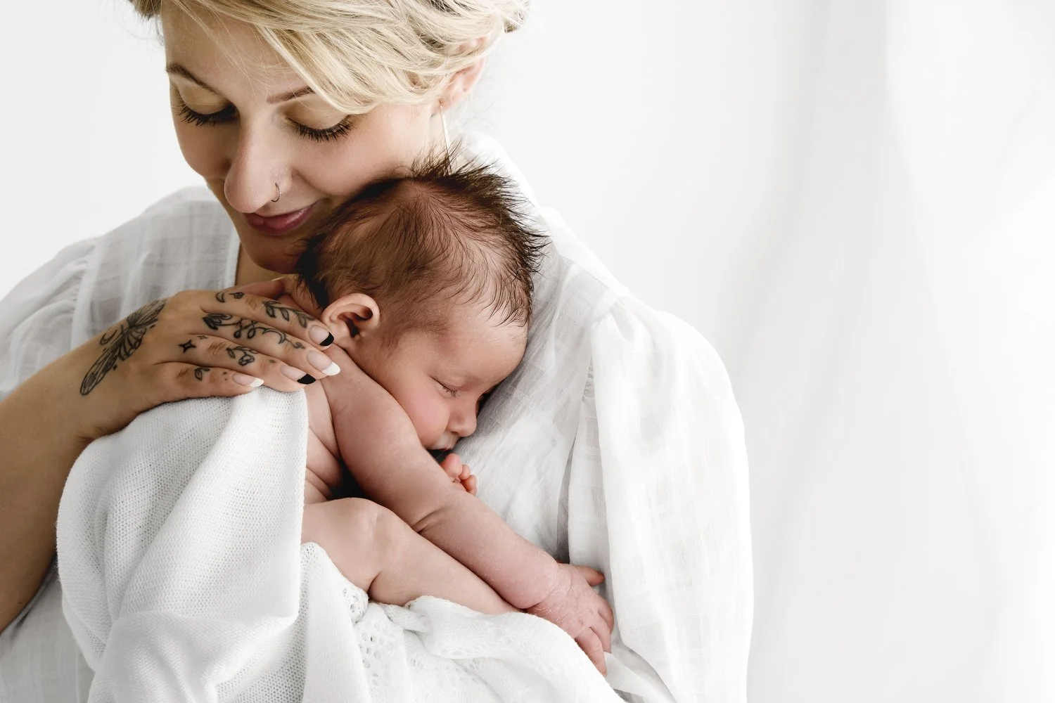 Mother holding her newborn baby during relaxed studio photoshoot in Dundee