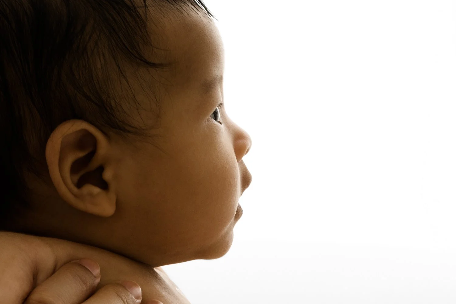 Side profile portrait of three month old baby with eyes open in natural light studio in Dundee