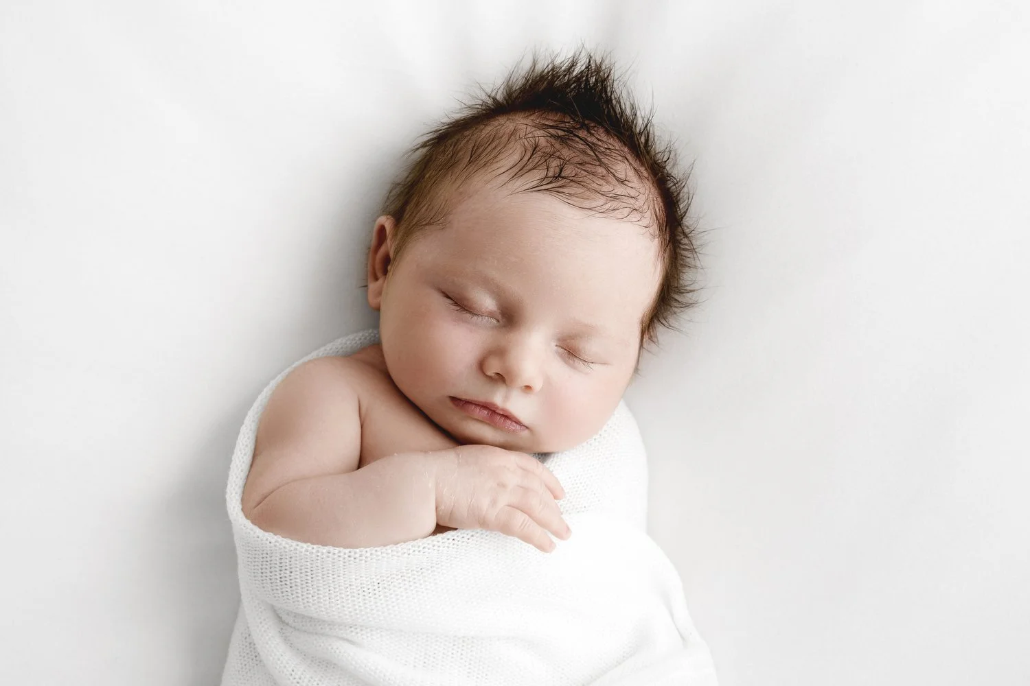 Sleeping newborn wrapped in white lace during Dundee photoshoot