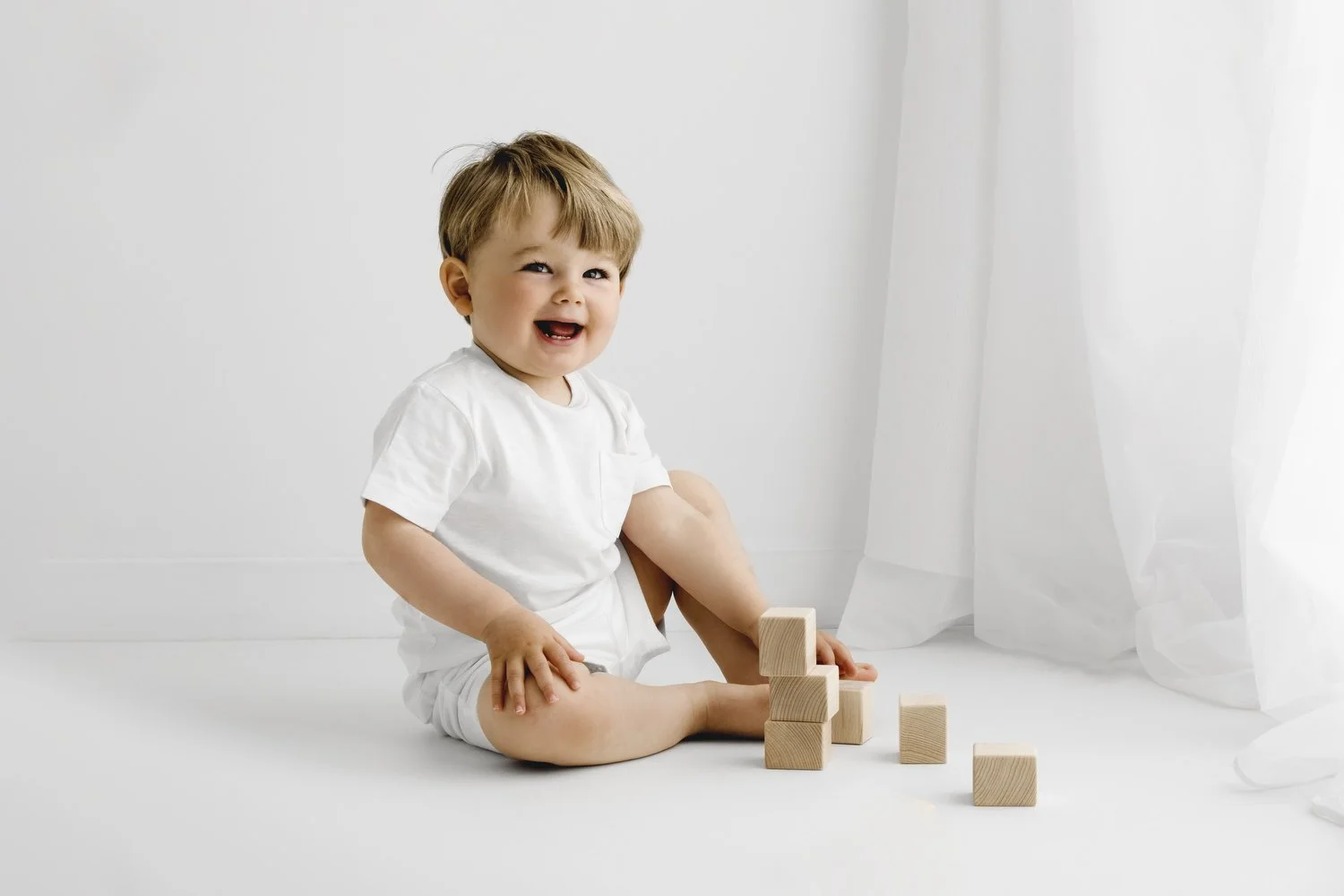 18 month old toddler with wooden bricks at natural photoshoot in dundee studio