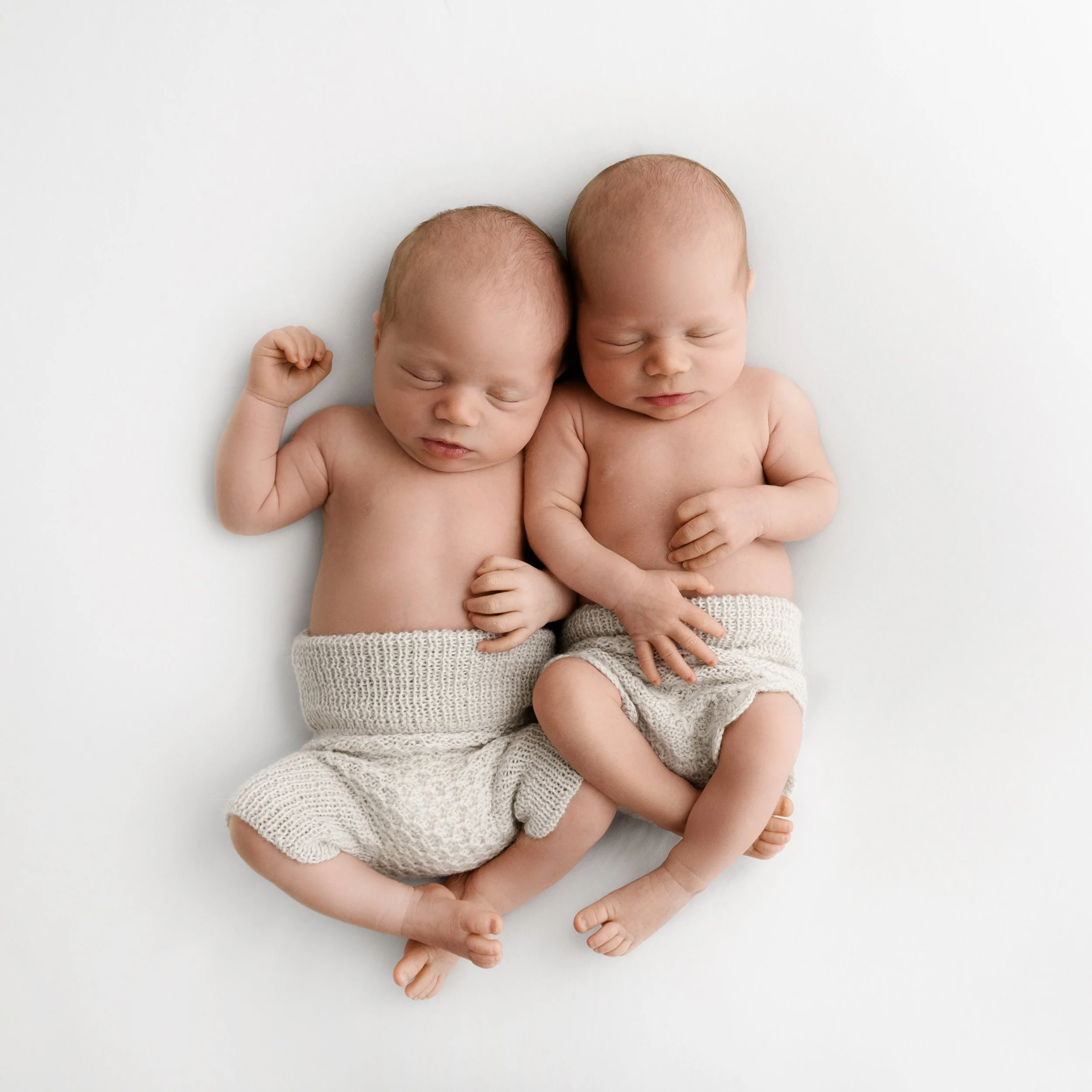 Newborn twins wearing simple knitted bloomers in natural pose at Dundee studio