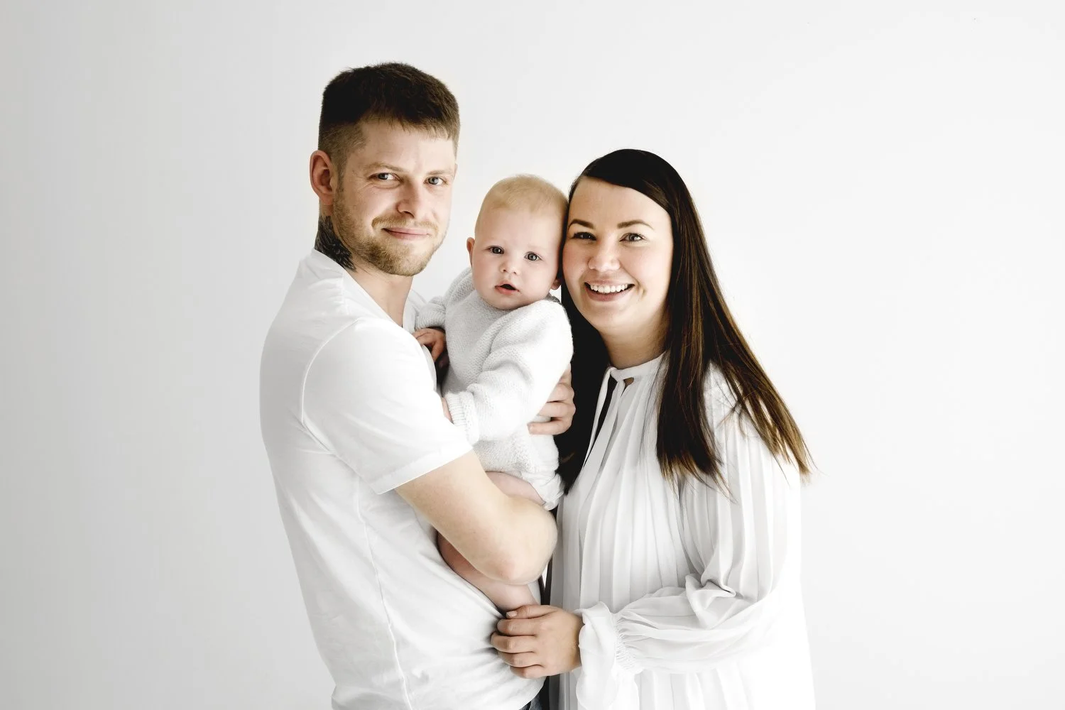 Parents holding their 9 month old baby during family photoshoot in Dundee studio