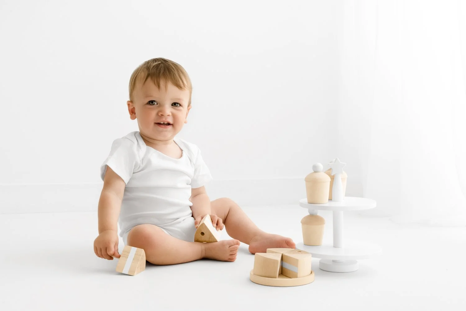 1st birthday photoshoot baby playing with wooden cake stand in Scotland