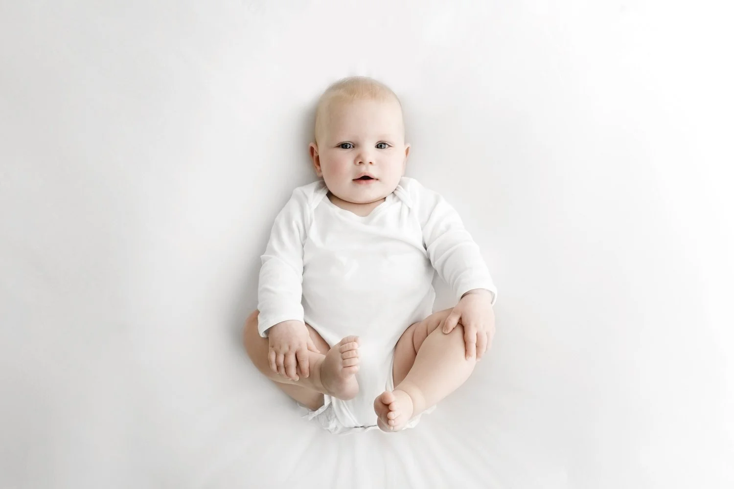 9 month old baby lying down during natural baby photoshoot in Dundee