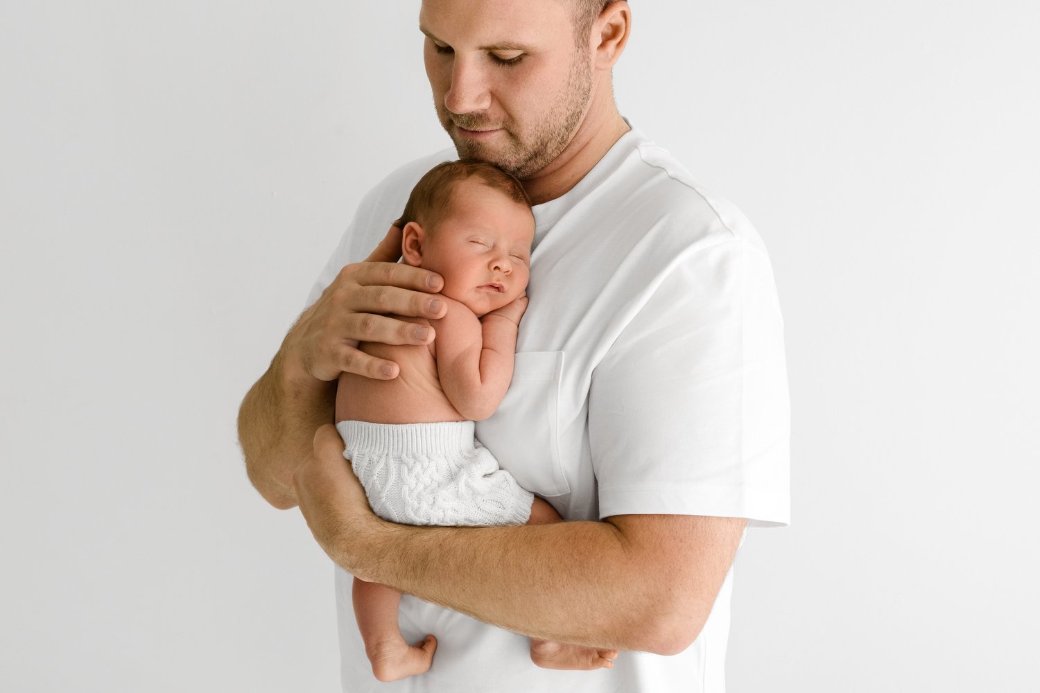 dad holding 14 day old newborn baby at Mabel and Moose studio Monifieth Dundee