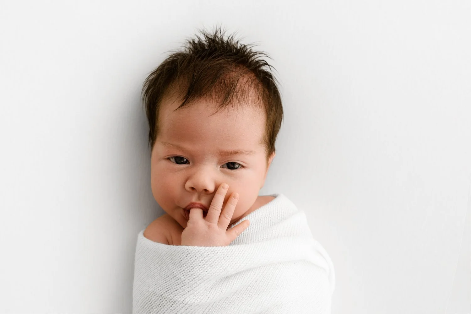 wide awake Image of baby swaddled simply, emphasizing calm, distraction-free photography setups