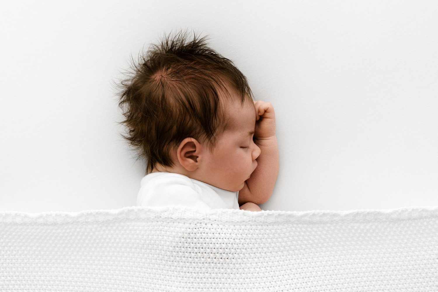 Newborn in relaxed pose to show how babies at 3–4 weeks can still be photographed like newborns