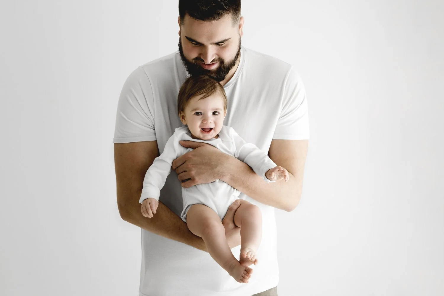 Dad holding baby in white vest at Mabel and Moose studio Dundee