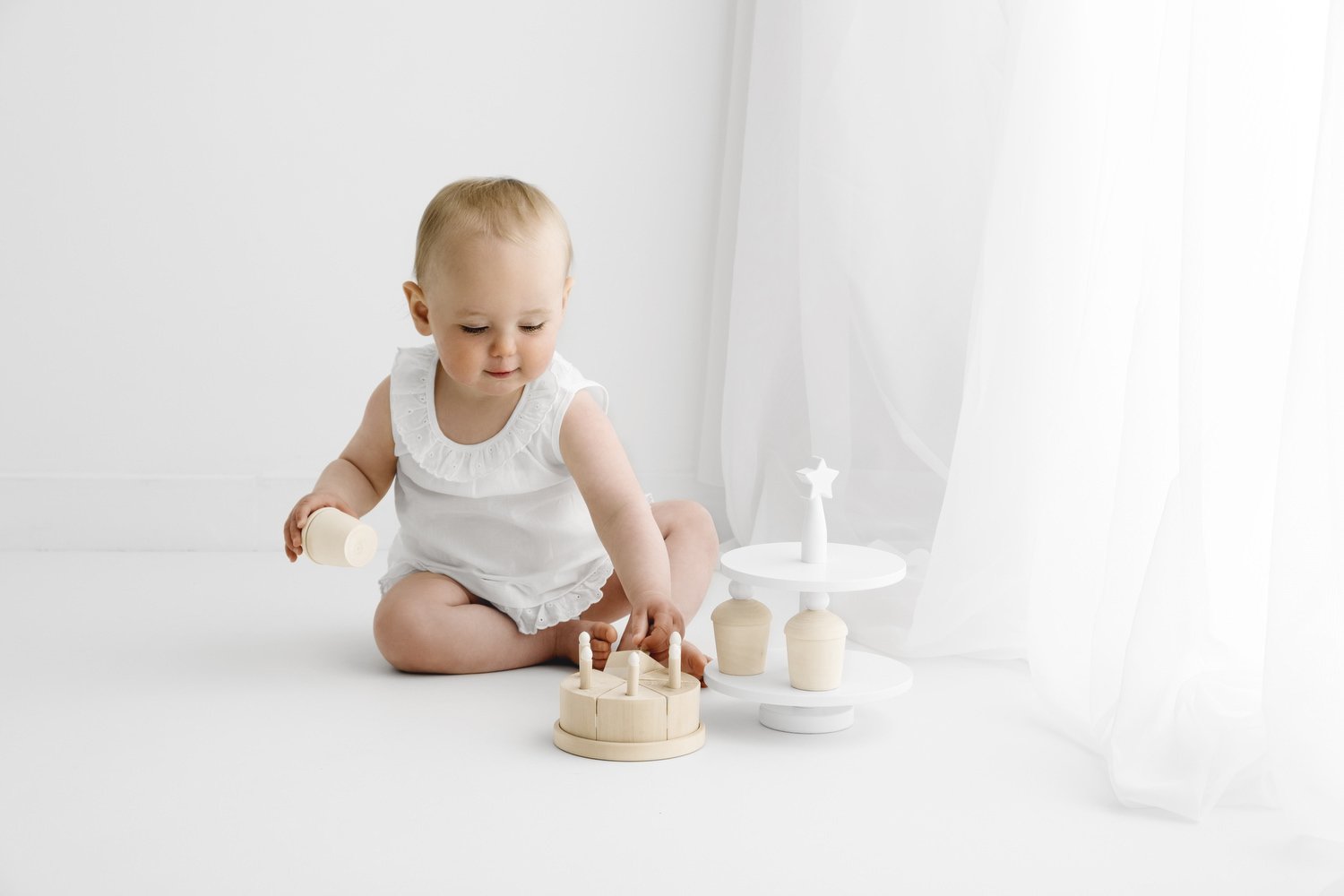 baby with wooden  cake at first birthday photoshoot in dundee