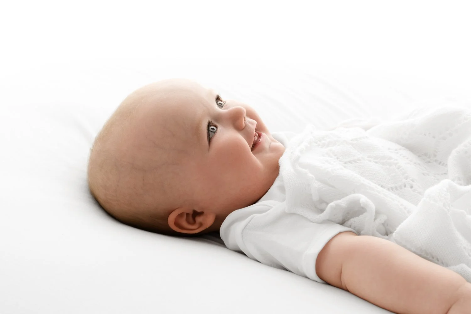 6 month old baby lying on it's back smiling photoshoot at Mabel and Moose studio Dundee