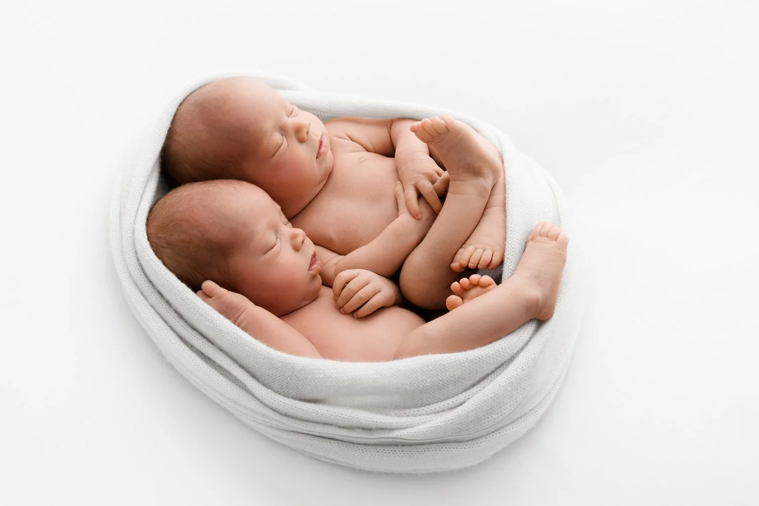 Newborn twins wrapped together in cocoon wrap at Mabel and Moose studio Dundee