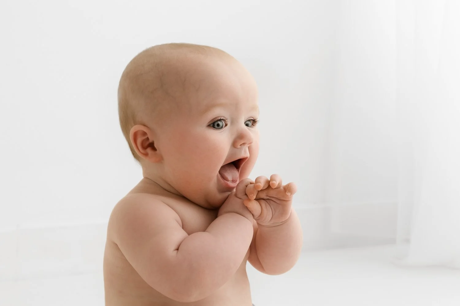 6 month old baby sitting up and chewing hands very naturally photoshoot at Mabel and Moose studio Dundee
