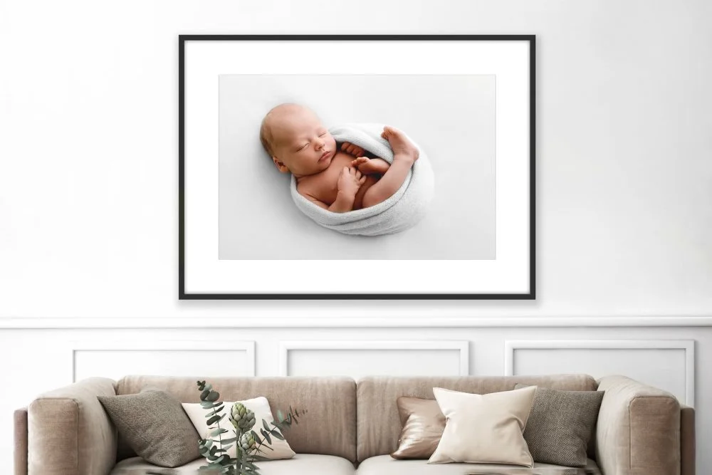 Minimalist framed newborn photograph on wall in Scandinavian inspired room setting