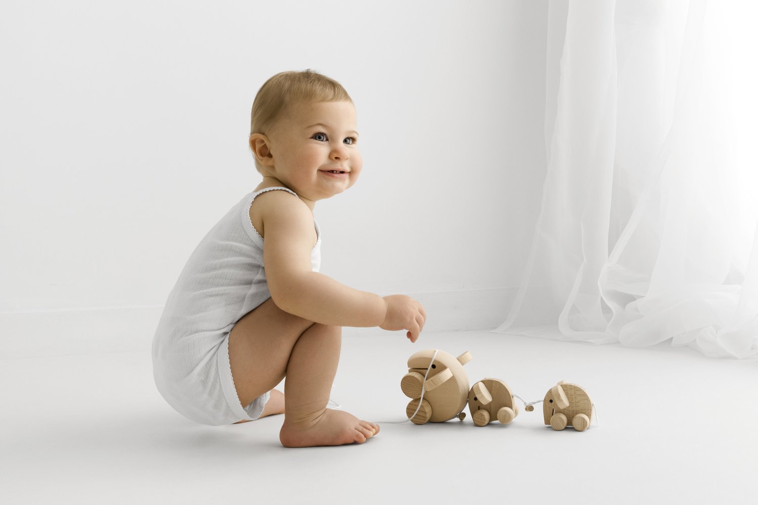 relaxed first birthday photo with wooden toys at a studio in scotland